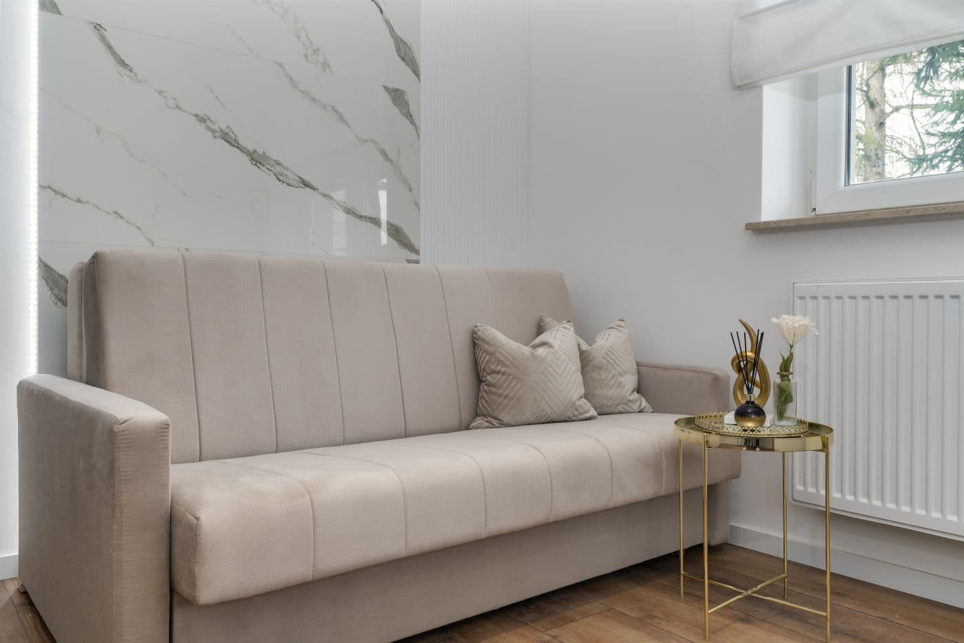A living room with a sofa, coffee table, and adjoining kitchen